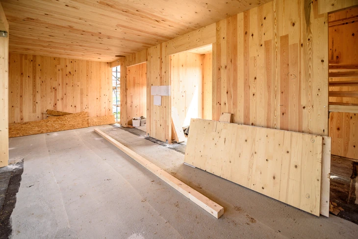 Intérieur de maison individuelle en construction avec ouvrier installant cloisons