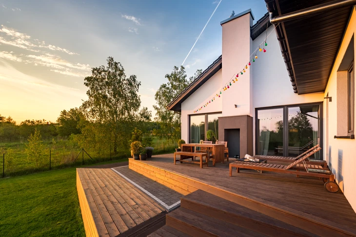 Terrasse extérieure moderne en bois exotique avec mobilier de jardin, chaises longues et table