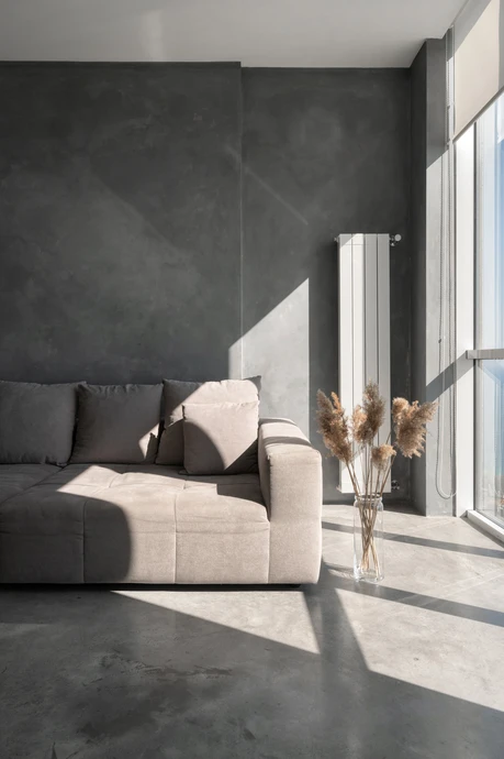 La lumière du soleil sur le sol en béton dans la chambre d'hôtel avec fenêtres panoramiques