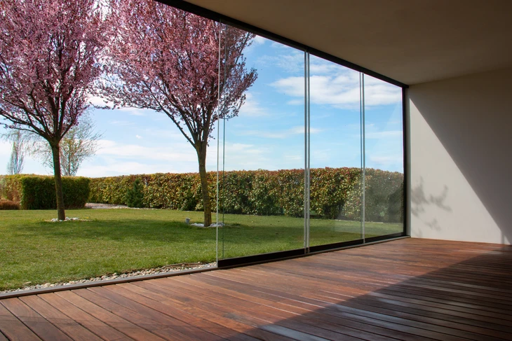 patio entouré d'une terrasse en bois, solarium en verre avec solarium surplombant la nature