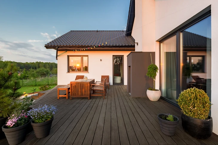 Terrasse extérieure moderne avec mobilier en teck, deck en bois composite, plantes ornementales en pots