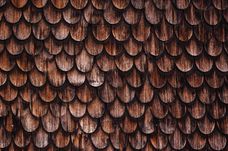 Façade extérieure d'un bâtiment recouverte de bardeaux de bois traditionnels disposés en écailles superposées