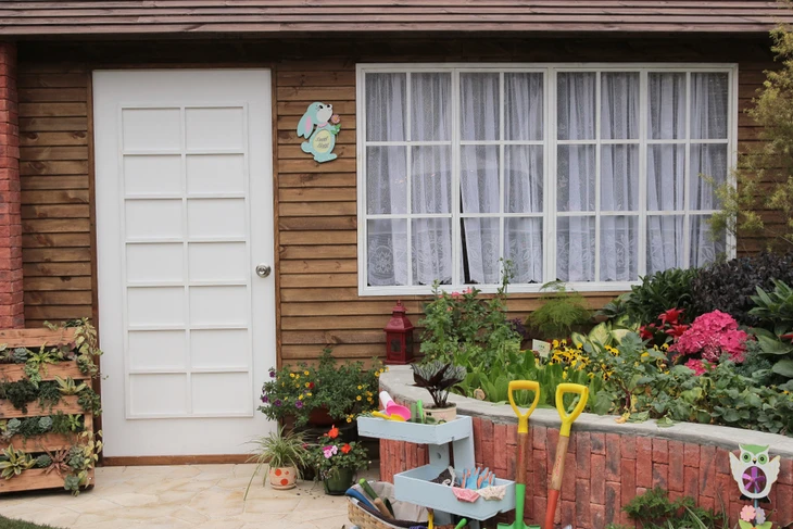 Extérieur résidentiel avec jardin aménagé devant maison en bardage bois