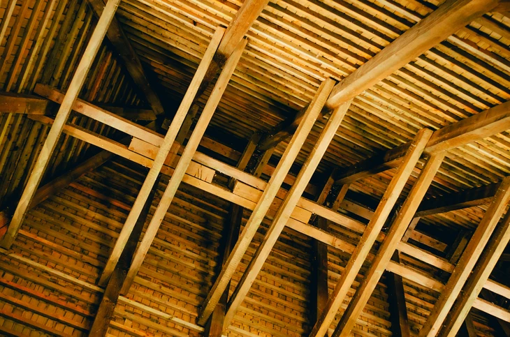 Intérieur d'une charpente traditionnelle en bois avec structure apparente