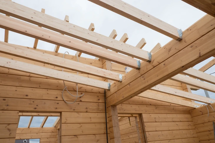 Chantier de construction d'une maison en bois massif empilé, vue intérieure depuis les combles