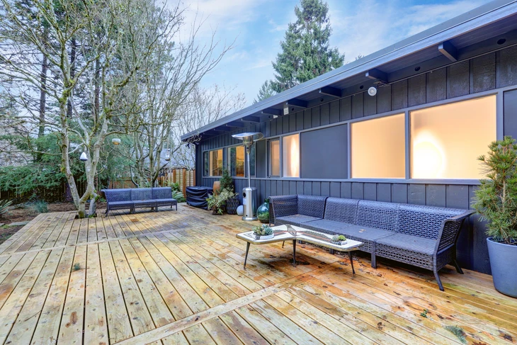 Terrasse extérieure résidentielle moderne avec salon de jardin gris sur deck en bois