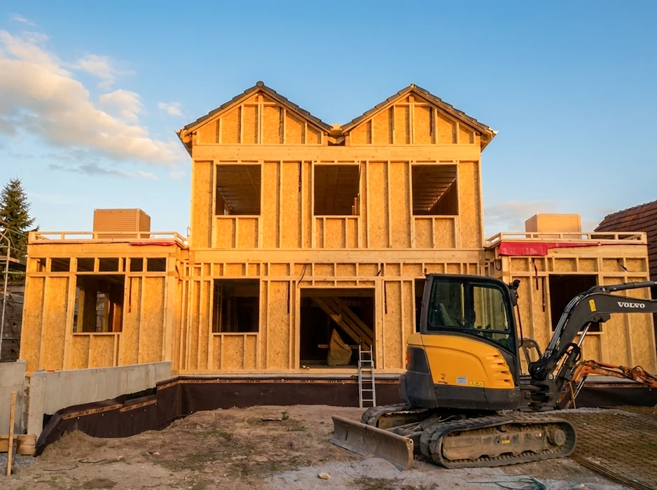 Chantier de construction d'une maison à ossature bois en cours, extérieur, vue de façade au coucher du soleil