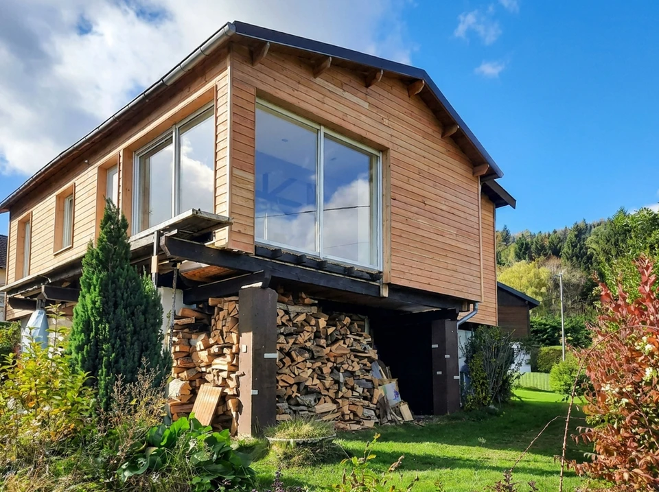 Maisons alsaciennes traditionnelles à colombages avec façades en bois et crépi, volets colorés bleus et rouges, toitures en tuiles d'argile orange